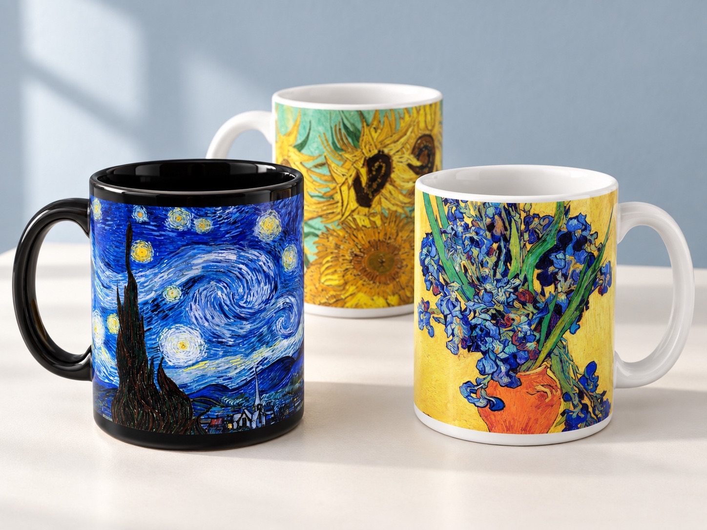 Van Gogh collection concept featuring a black Starry Night mug and white Sunflowers and Irises mugs